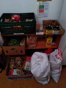 Das Foto zeigt ein Regal, Kisten und Beutel mit vielen Lebensmitteln.